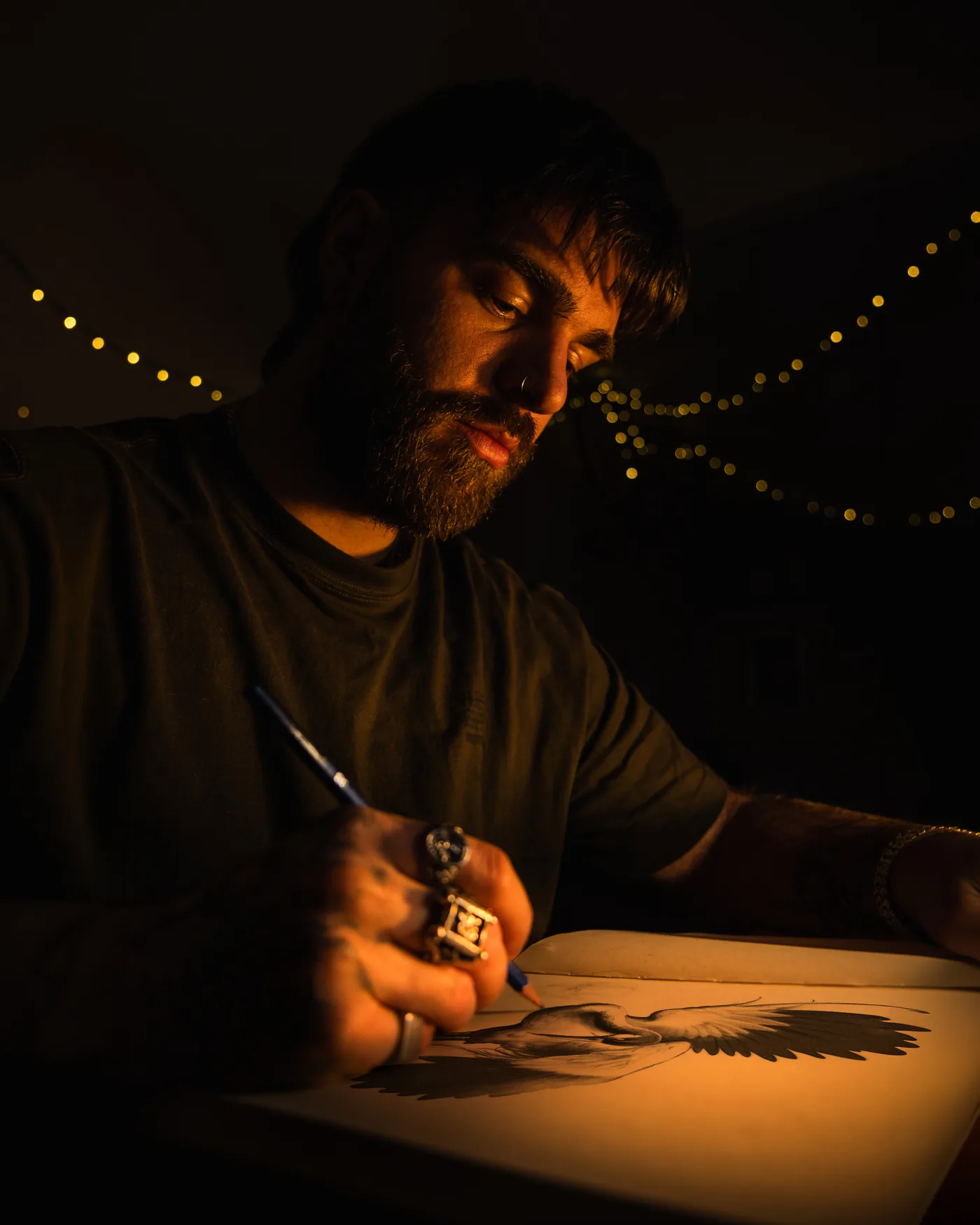 Jeremy drawing a design by lamplight